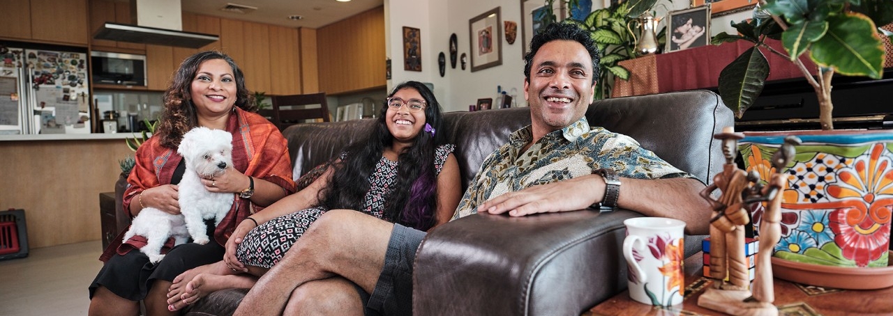 Dipesh Chaudhury, Assistant Professor of Biology, right, with his daughter, center, and wife, left, holding their pet dog.